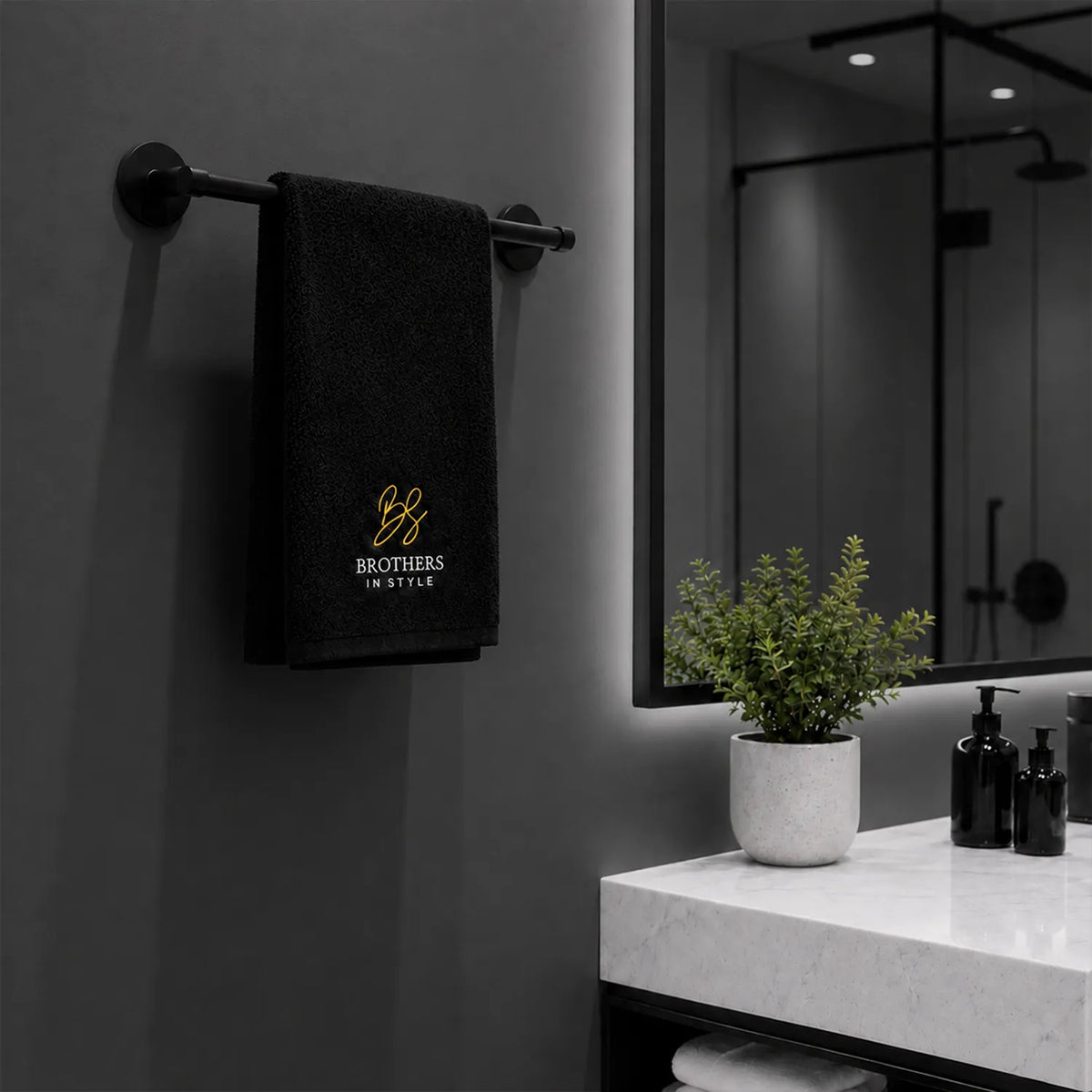 Zwarte katoenen handdoek hangend aan handdoekhouder in moderne badkamer.