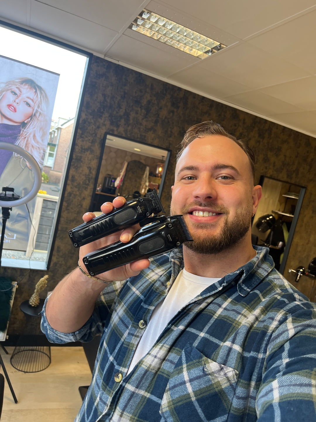 Barbier toont twee professionele tondeuses in zijn barbershop