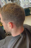 Video waarin een barbier met een tondeuse een strakke fade en haarlijn afwerkt.