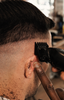 Barbier demonstreert de Viking Blade tondeuse tijdens het creëren van een strakke fade
